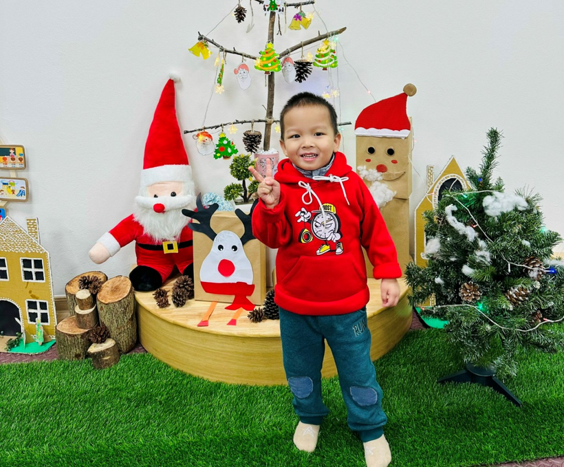 A child standing in front of a christmas display

Description automatically generated