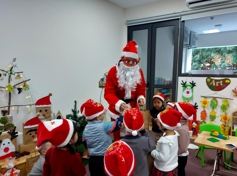 A group of kids in a room with santa claus

Description automatically generated