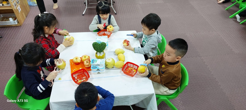 A group of children sitting at a table

Description automatically generated