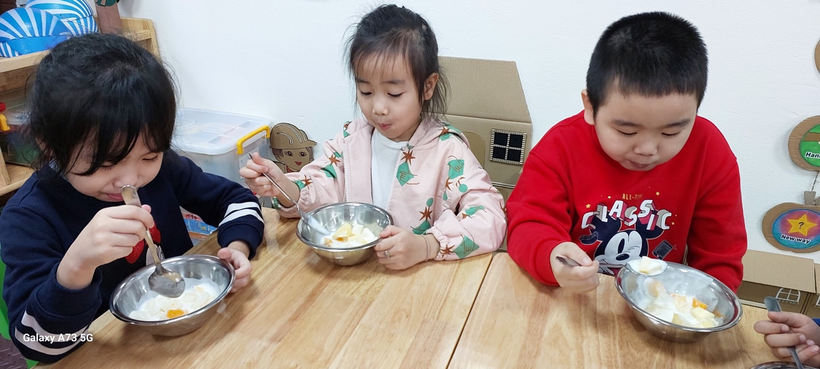 A group of children eating at a table

Description automatically generated