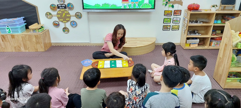 A group of children sitting on the floor and a person teaching a lesson

Description automatically generated
