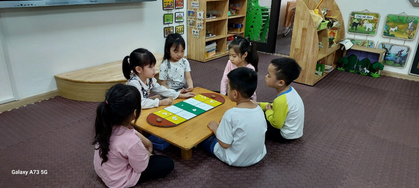 A group of children sitting around a table

Description automatically generated